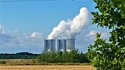 Das Kraftwerk Lippendorf am Horizont hinter einem abgemähten Feld 