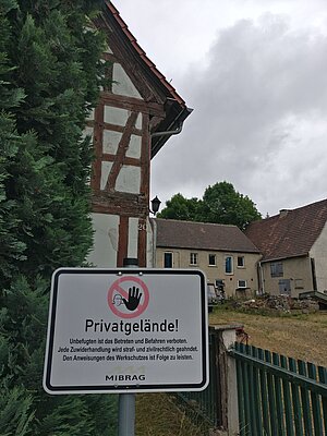 altes Fachwerkhaus mit Schild davor "Privatgelände  Betreten verboten"