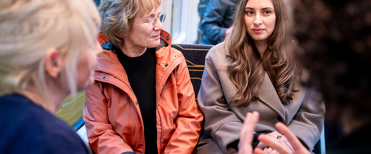 Leute unterhalten sich in der Straßenbahn